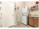 Functional laundry area with a stackable washer/dryer and adjacent utility sink next to entry door at 3055 N Red Mtn # 178, Mesa, AZ 85207