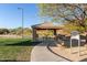 Community park picnic pavilion with tables, benches, trashcan and playground in background at 3055 N Red Mtn # 178, Mesa, AZ 85207