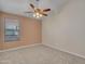 Cozy bedroom featuring neutral carpeting, a ceiling fan, and a window for natural light at 3129 W Walter Way, Phoenix, AZ 85027