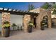 A welcoming outdoor seating area and stone archway frames the ornate front door at 3348 E Eva St, Phoenix, AZ 85028