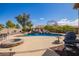 Beautiful backyard with custom pool, rock waterfall, fire pit, outdoor seating, and built-in bbq at 3350 W Ivanhoe Ct, Chandler, AZ 85226