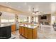 Spacious kitchen featuring an island, stainless steel appliances, lots of light, and a cozy fireplace in the connecting living space at 3350 W Ivanhoe Ct, Chandler, AZ 85226