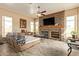 Stylish living room featuring a stone fireplace, large windows, and comfortable seating for relaxation and entertainment at 3350 W Ivanhoe Ct, Chandler, AZ 85226