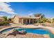 Inviting backyard featuring a sparkling pool, covered patio, and cozy fire pit area for relaxation and entertainment at 3350 W Ivanhoe Ct, Chandler, AZ 85226