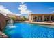 Beautiful backyard pool with a rock waterfall feature and covered patio area for outdoor entertaining at 3350 W Ivanhoe Ct, Chandler, AZ 85226