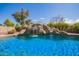 Custom pool with a large rock waterfall and water slide feature and lush landscaping at 3350 W Ivanhoe Ct, Chandler, AZ 85226