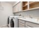 Laundry room features a washer, dryer, utility sink, and plenty of storage cabinets at 3435 E Renee Dr, Phoenix, AZ 85050