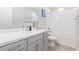 Bright bathroom with gray cabinets, double sink, large mirror, and shower-tub with white tiled walls at 3483 W Verde River Rd, San Tan Valley, AZ 85144