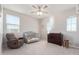 Light-filled bedroom with a ceiling fan, a crib, a recliner, and a changing table at 3483 W Verde River Rd, San Tan Valley, AZ 85144