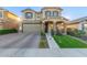 Charming two-story home featuring a well-manicured lawn, a two-car garage and stone-accented driveway at 3483 W Verde River Rd, San Tan Valley, AZ 85144