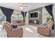 Inviting living room featuring neutral tones, a modern fireplace, and a large screen television at 3483 W Verde River Rd, San Tan Valley, AZ 85144