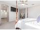 Bright main bedroom features four poster bed, ceiling fan, and an ensuite bath with a glass shower at 3483 W Verde River Rd, San Tan Valley, AZ 85144