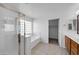 Bright bathroom featuring a glass enclosed shower and separate tub with a glass block window at 3524 W Alyssa Ln, Phoenix, AZ 85083