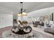 Cozy dining area adjacent to living room has modern hanging lights and elegant table setting at 3524 W Alyssa Ln, Phoenix, AZ 85083