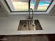 The modern kitchen sink has bright countertops and a window view to the backyard pool at 3524 W Alyssa Ln, Phoenix, AZ 85083