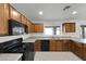 Kitchen features wood cabinets, a black microwave, and a black range at 3524 W Alyssa Ln, Phoenix, AZ 85083