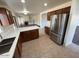 Spacious kitchen featuring stainless steel refrigerator with adjacent open-concept living space at 3524 W Alyssa Ln, Phoenix, AZ 85083