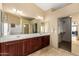 Bathroom featuring double sinks, cabinets, shower, closet, and large mirrors at 3608 N Mansfield Dr, Litchfield Park, AZ 85340