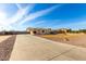 Long concrete driveway leading to a well-maintained home in a desert landscape at 3608 N Mansfield Dr, Litchfield Park, AZ 85340