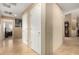 Hallway with tan walls and marble flooring, featuring multiple doorways and a decorative grandfather clock at 3608 N Mansfield Dr, Litchfield Park, AZ 85340