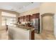 Spacious kitchen featuring dark wood cabinets, stainless steel appliances, and a large island with granite countertop at 3608 N Mansfield Dr, Litchfield Park, AZ 85340