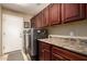 Laundry room featuring a washer and dryer, dark cabinetry, and a countertop with tiled backsplash at 3608 N Mansfield Dr, Litchfield Park, AZ 85340