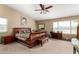 Spacious main bedroom featuring a decorative wooden bed frame, ceiling fan, and large windows at 3608 N Mansfield Dr, Litchfield Park, AZ 85340