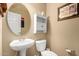 Charming powder room with pedestal sink, toilet, and Coca-Cola themed decor at 3608 N Mansfield Dr, Litchfield Park, AZ 85340