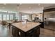 Open-concept kitchen featuring a large island, stainless steel fridge, and view to the living area at 36276 N Secret Garden Path, Queen Creek, AZ 85140