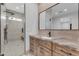 Beautiful bathroom featuring wood cabinets, granite countertops, a sink, mirror, and glass enclosed shower at 38024 N 15Th Ave, Phoenix, AZ 85086