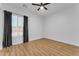 Spare bedroom with wood-look floors, fan, and window with curtains at 38024 N 15Th Ave, Phoenix, AZ 85086