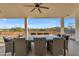 Covered patio with a large dining table and chairs, offering beautiful views of the surrounding landscape at 38024 N 15Th Ave, Phoenix, AZ 85086