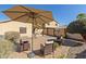 Inviting backyard retreat with a shaded patio and comfortable seating beneath a large umbrella at 3967 E Hematite Ln, San Tan Valley, AZ 85143