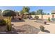 Lush backyard features desert landscaping, a stone patio, and cozy seating arrangements at 3967 E Hematite Ln, San Tan Valley, AZ 85143