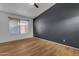 Bright bedroom with window, wood-look floors, and a sleek gray accent wall at 4165 W Park Ave, Chandler, AZ 85226