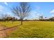 A grassy community green space featuring a dirt path and a few trees at 4165 W Park Ave, Chandler, AZ 85226