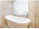 Bright bathroom features a freestanding tub with chrome fixtures and a glass block window for natural light at 4251 E Desert Forest Trl, Cave Creek, AZ 85331