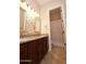 Well-lit bathroom featuring dual sinks with granite countertops, stone accent wall, and a separate toilet area at 4251 E Desert Forest Trl, Cave Creek, AZ 85331