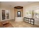 Bright living room with natural light, travertine floors, and French doors to the library at 4251 E Desert Forest Trl, Cave Creek, AZ 85331