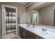 Bathroom with a double sink vanity, large mirror, and shower with a striped curtain at 43805 N Ericson Ln, New River, AZ 85087