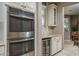 Gourmet kitchen with stainless steel double ovens, a wine fridge, and elegant cabinetry at 43805 N Ericson Ln, New River, AZ 85087