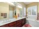 Bathroom featuring double sinks, a large mirror, and a soaking tub with shuttered window at 4546 E Sierra Sunset Trl, Cave Creek, AZ 85331