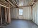 Interior view of a room under construction with insulation and framing, featuring a window with natural light at 47463 W Kenner Dr, Maricopa, AZ 85139