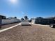 Open backyard with gravel and block wall featuring rear home elevation with storage building at 4836 W Redfield Rd, Glendale, AZ 85306