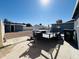 Gravel backyard with storage buildings and a utility trailer near the rear of the house at 4836 W Redfield Rd, Glendale, AZ 85306