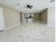 Spacious living area with modern ceiling fan, tiled floors, and a glimpse of a stylish, white kitchen at 4836 W Redfield Rd, Glendale, AZ 85306