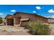 Tan single-story home with a front carport, low maintenance desert landscaping, and a blue sky backdrop at 485 S Pino Cir, Apache Junction, AZ 85120