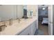 Bright bathroom featuring dual sinks, white cabinetry, and a view into the bedroom at 5121 N 181St Dr, Litchfield Park, AZ 85340