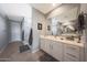 Modern bathroom featuring dual sinks, white cabinets, walk-in shower, and tile floors at 5121 N 181St Dr, Litchfield Park, AZ 85340