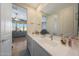 Bathroom features double sinks, white cabinets, a large mirror, and tile flooring at 5121 N 181St Dr, Litchfield Park, AZ 85340